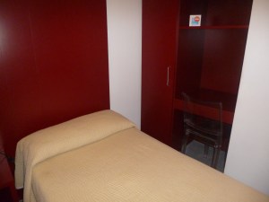 Tiny bed and desk area . . . don't you love the red?
